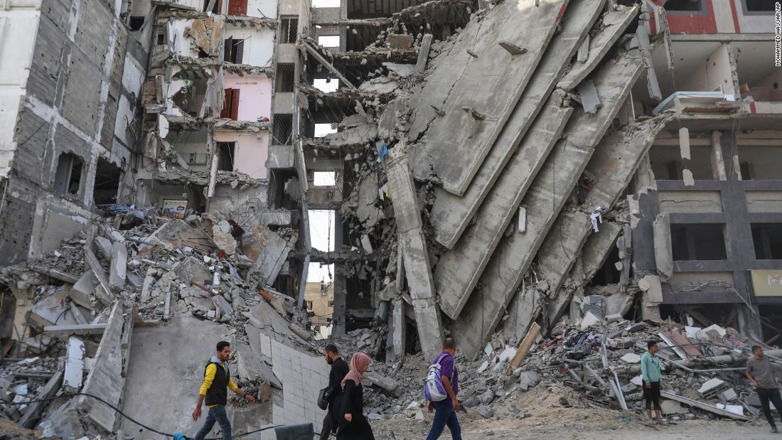Palestinians walk through destruction in Gaza City on November 24 as a temporary truce between Israel and Hamas took effect.