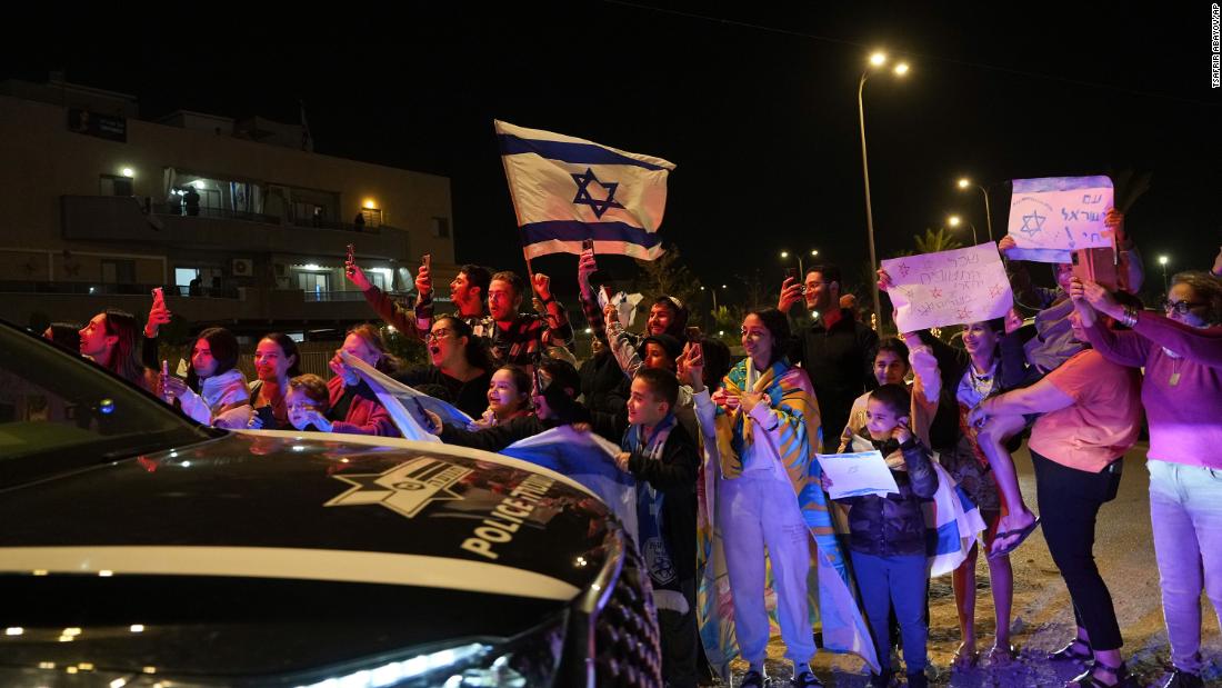 People welcome a convoy carrying newly released hostages in Ofakim, Israel, on Sunday, November 26.