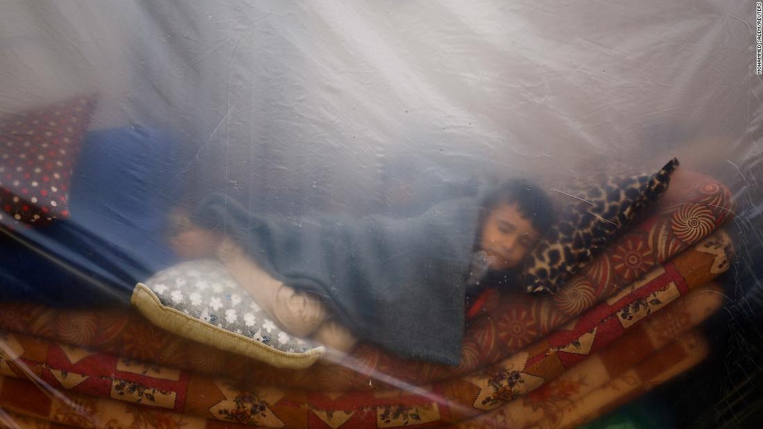 A child sleeps in a makeshift shelter in a new camp sheltering displaced Palestinians who fled their houses due to Israeli strikes, in Rafah, southern Gaza, on December 5.