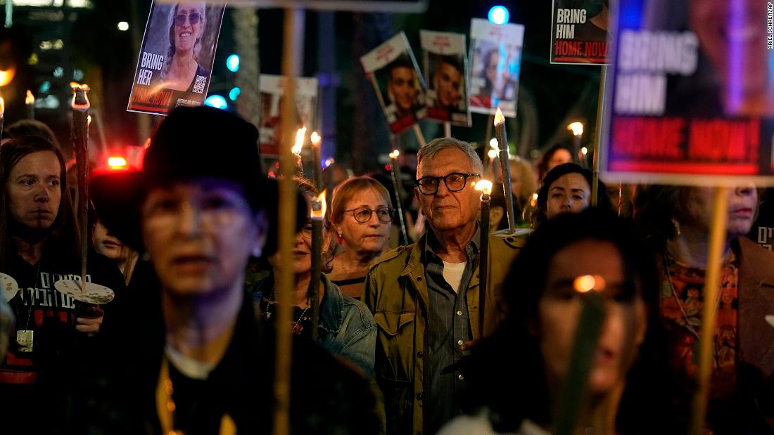 Relatives and friends of hostages held in Gaza by the Hamas militant group light torches and march as they call for their release during the Jewish holiday of Hanukkah in the Hostages Square at the Museum of Art in Tel Aviv, Israel, on December 7.