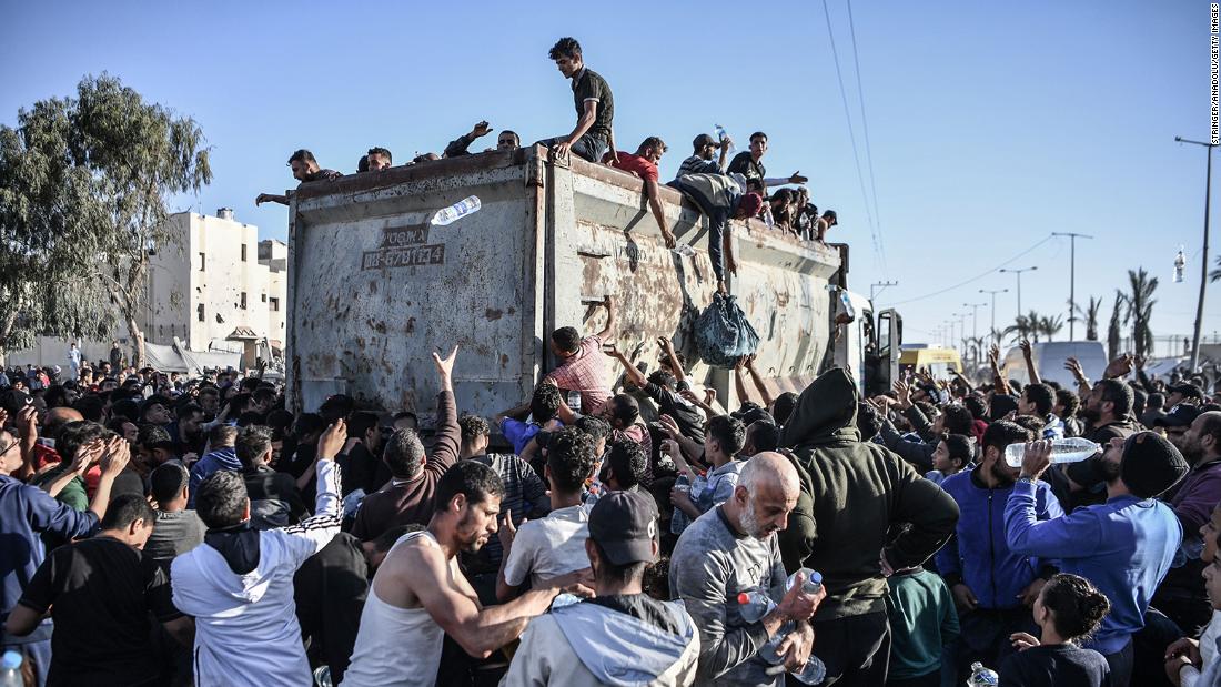 Palestinians crowd around a truck that&#39;s distributing bottles of water in Rafah, Gaza, on December 11.