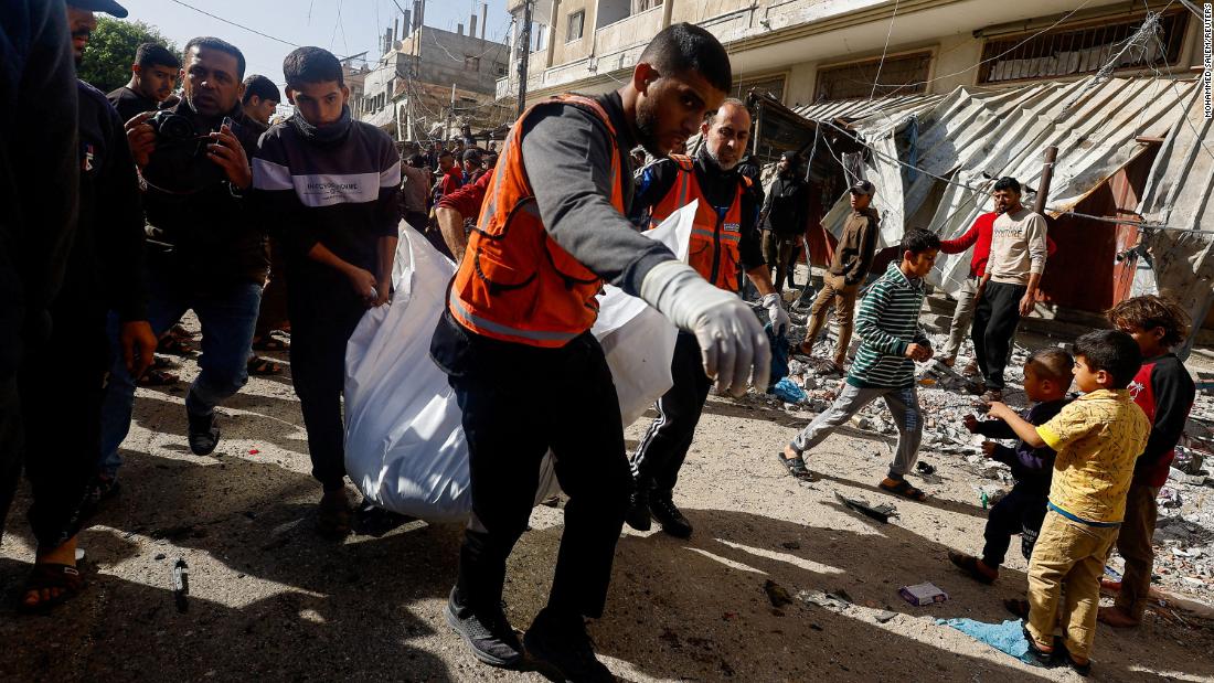 Palestinians carry a casualty near the site of an Israeli strike in Rafah, Gaza, on December 22.