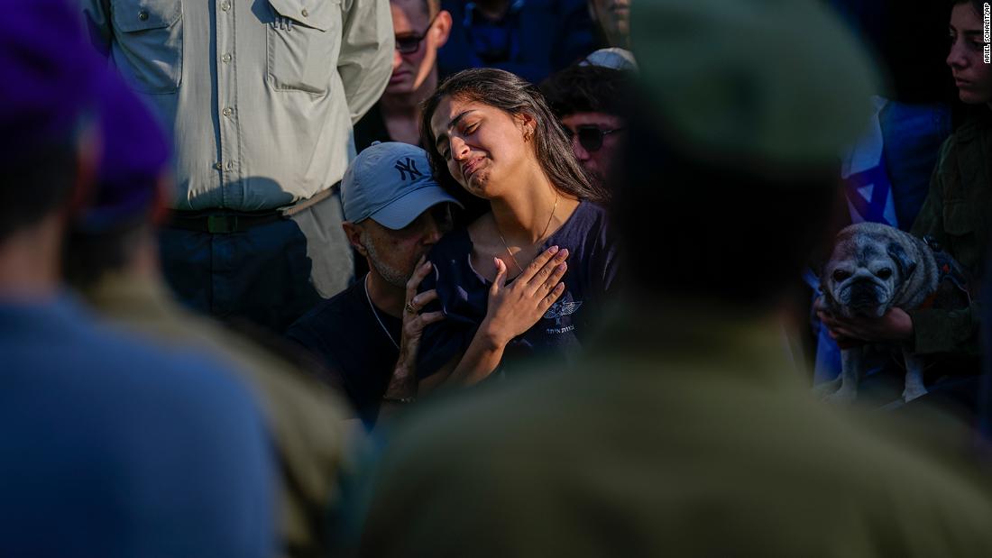 Mourners gather in grief around the grave of Israeli soldier Captain Harel Ittah during his funeral in Netanya, Israel, on December 31.