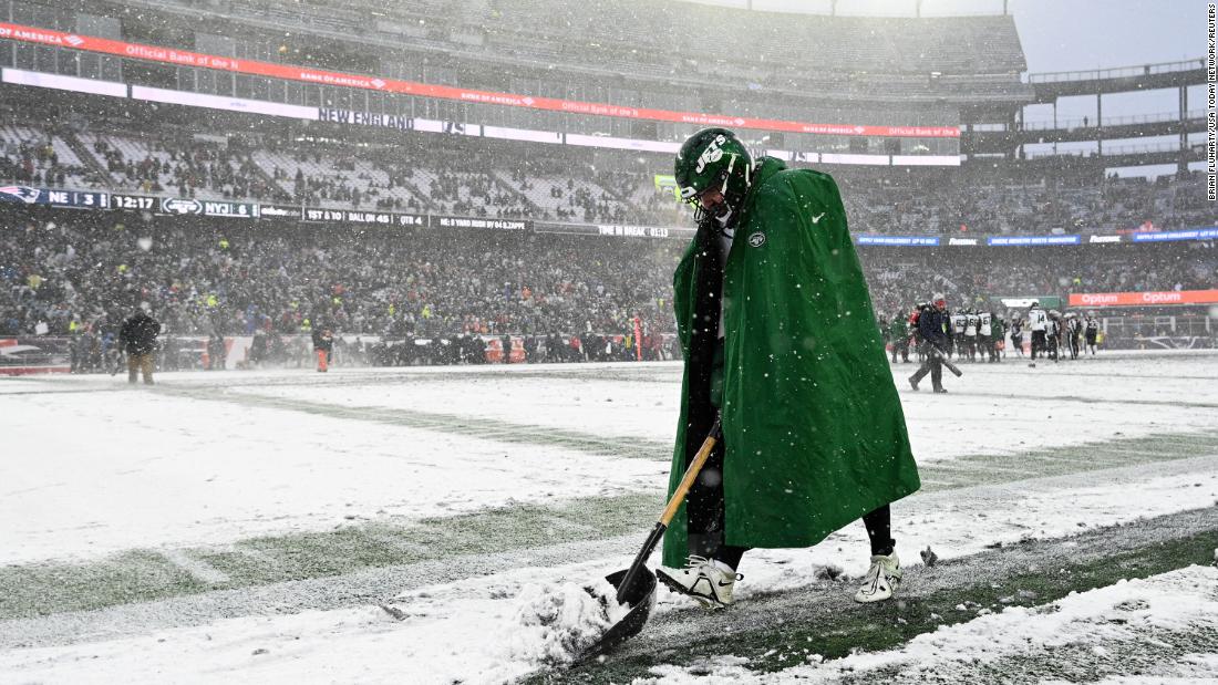 New York Jets long snapper Thomas Hennessy shovels snow along the sideline during a game at New England on January 7. The Jets won 17-3, but both teams finished the season well out of the playoff picture.