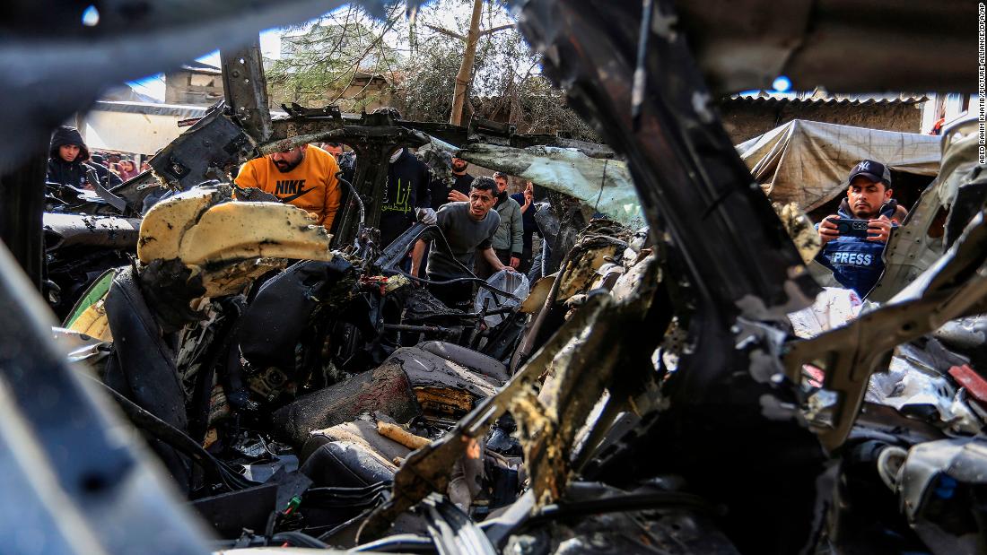 People inspect the ruins of a civilian car after it was fatally struck by an Israeli drone in Rafah, Gaza, on January 8.