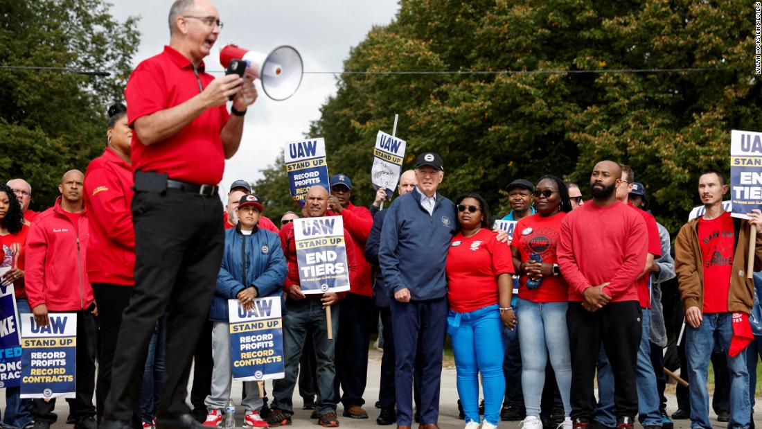 Shawn Fain, president of the United Auto Workers, speaks as Biden, center, joins &lt;a href=&quot;https://www.cnn.com/2023/09/26/politics/biden-picket-line-michigan-uaw/index.html&quot; target=&quot;_blank&quot;&gt;striking union members &lt;/a&gt;on the picket line in Belleville, Michigan. Biden made history by being the first sitting president to join a picket line.