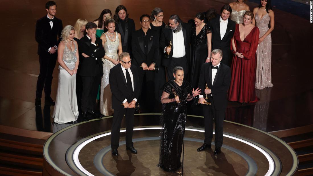 Producer Emma Thomas speaks on stage after &quot;Oppenheimer&quot; won the Academy Award for best picture on Sunday, March 10. At front right is her husband, Christopher Nolan, who also won the Oscar for best director.