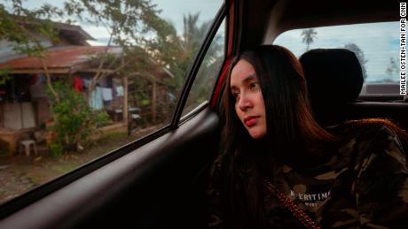 Bianca Balala looks out the window of a car as she passes through her village in the Philippines.