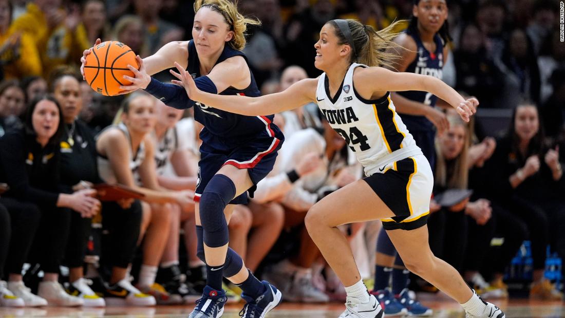 Bueckers fights for a loose ball with Iowa guard Gabbie Marshall during the first half. The Huskies held a 32-26 lead at halftime.