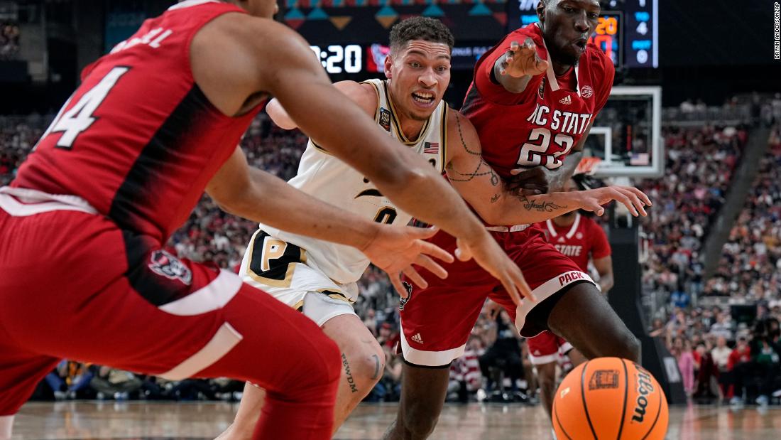 Gillis, center, and NC State forward Mohamed Diarra, right, chase down a loose ball.