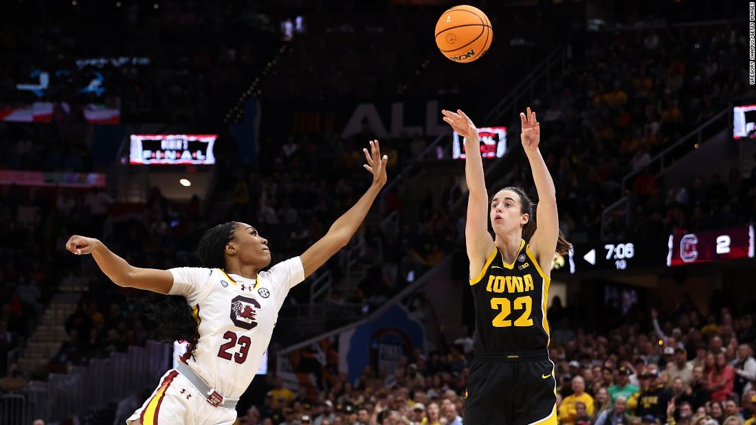 Clark shoots a three-point basket over Hall.