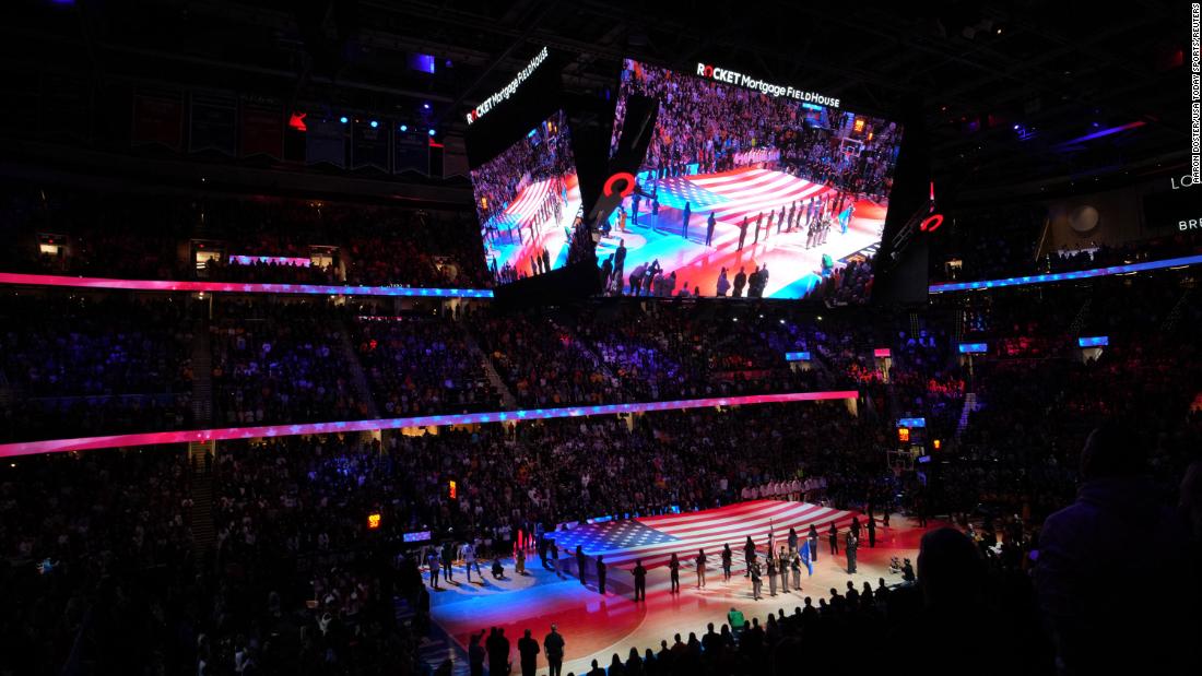 Players stand for the national anthem ahead of the game.