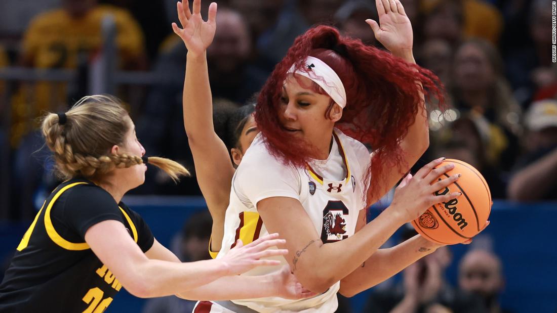 South Carolina&#39;s Cardoso keeps the ball away from Martin and Stuelke of the Iowa Hawkeyes.