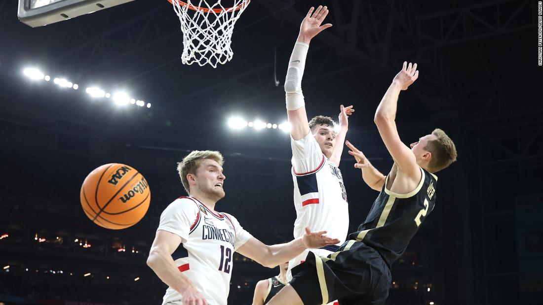 Purdue&#39;s Fletcher Loyer loses control of the ball while being guarded by UConn&#39;s Cam Spencer and Donovan Clingan.